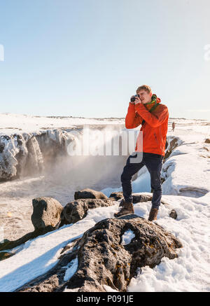 Photographing Man at Selfoss Waterfall in Winter, Gorge, North Iceland, Iceland Stock Photo