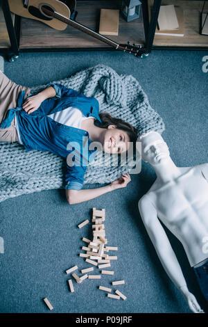 overhead view of woman and mannequin lying on floor near blocks wood game, perfect relationship dream concept Stock Photo