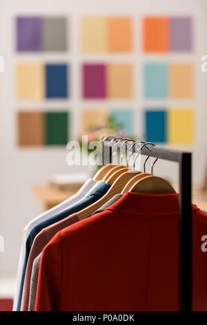 fashionable clothes on hangers in modern office Stock Photo
