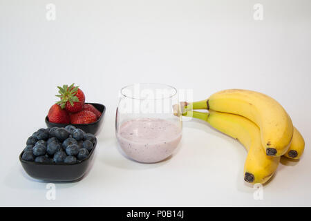 Fruit smoothie in a clear glass made from blueberry, banana and strawberry. Stock Photo