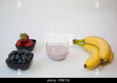 Fruit smoothie in a clear glass made from blueberry, banana and strawberry. Stock Photo