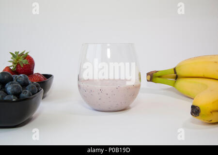 Fruit smoothie in a clear glass made from blueberry, banana and strawberry. Stock Photo