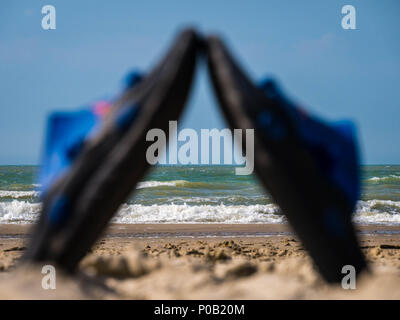 Upright placed thongs on an empty beach at low tide in Bray-Dunes, France Stock Photo