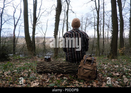 Man with backpack in wild forest Stock Photo