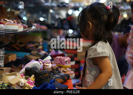 Family Shopping for Shoes for celebration of Hari Raya Aidilfitri (Eid al-Fitr) at a street Market in Penayong, Banda Aceh, Indonesia Stock Photo
