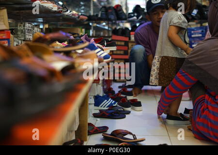 Banda Aceh, Aceh / Indonesia - June 8 2018 :Family Shopping for Shoes for celebration of Hari Raya Aidilfitri (Eid al-Fitr) at a street Market in Pena Stock Photo