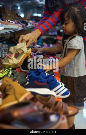 Banda Aceh, Aceh / Indonesia - June 8 2018 :Family Shopping for Shoes for celebration of Hari Raya Aidilfitri (Eid al-Fitr) at a street Market in Pena Stock Photo