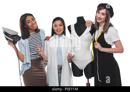 Beautiful smiling dressmakers holding tailor tools while working with white bodysuit on dummy Stock Photo