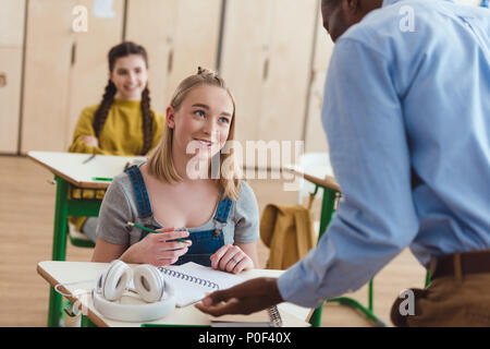 Rear view of african american teacher talking to high school teenage student Stock Photo