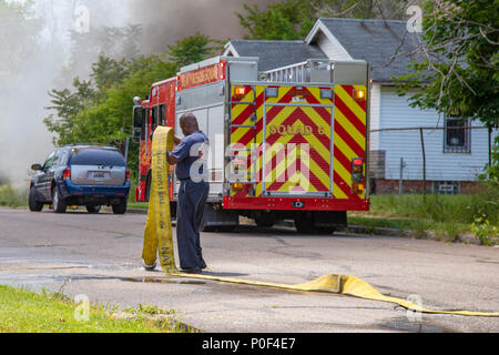 Detroit, Michigan - A firefighter handles a fire hose at a building fire on Detroit's east side. Stock Photo