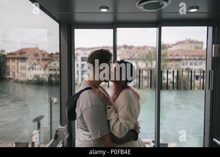 young couple in love kissing while enjoying beautiful Bern cityscape and lake
