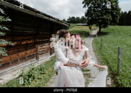 handsome groom kissing and hugging bride in wedding dress, Alps Stock Photo