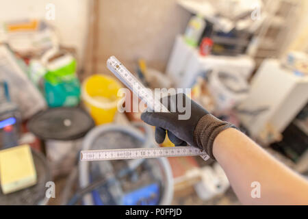 Hand holds a german double meter stick on a construction site Stock Photo