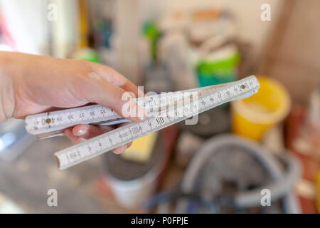 Hand holds a german double meter stick on a construction site Stock Photo