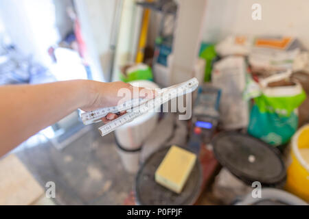Hand holds a german double meter stick on a construction site Stock Photo