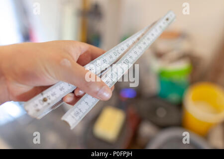 Hand holds a german double meter stick on a construction site Stock Photo