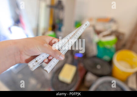 Hand holds a german double meter stick on a construction site Stock Photo