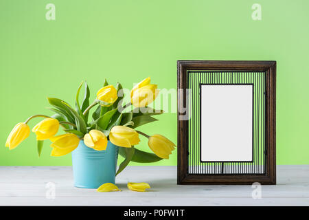 Yellow tulips with white frame on a white table Stock Photo