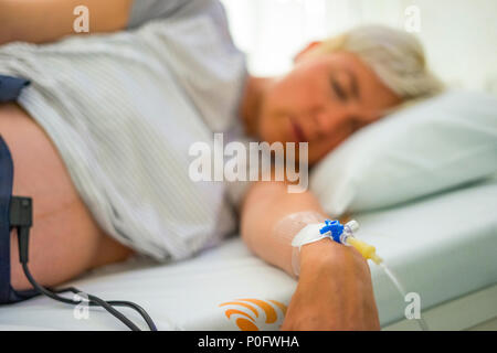 Peripheral venous catheter on the hand of laying down, pregnant woman Stock Photo