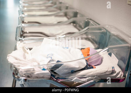 Newborn baby boy in his small transparent portable hospital bed Stock Photo