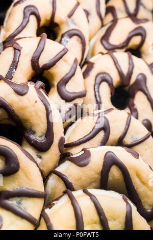 Many delicious sweet chocolate donuts in the bakery