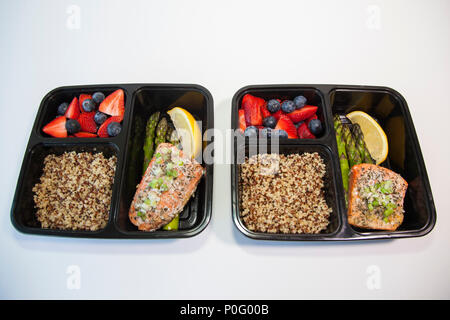Planned meals in containers - salmon with asparagus, quinoa and fresh fruit. Stock Photo