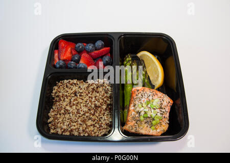 Planned meals in containers - salmon with asparagus, quinoa and fresh fruit. Stock Photo