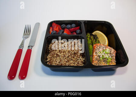 Planned meals in containers - salmon with asparagus, quinoa and fresh fruit. Stock Photo