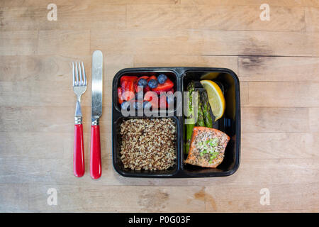 Planned meals in containers - salmon with asparagus, quinoa and fresh fruit. Stock Photo