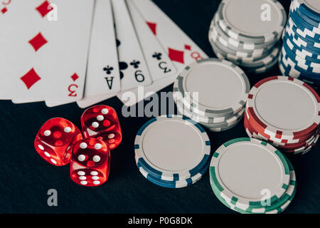 Stacks of chips with dice and playing cards on casino table Stock Photo