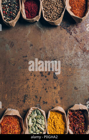 elevated view of indian spices in paper bags on brown grungy table Stock Photo