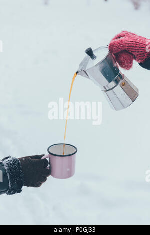 partial view of man pouring hot coffee into cup on winter day Stock Photo