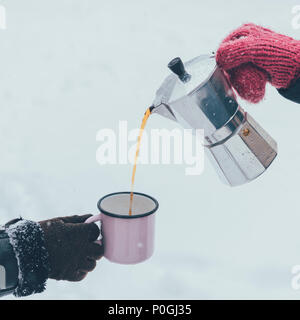 partial view of man pouring hot coffee into cup on winter day Stock Photo