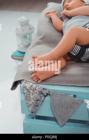 selective focus of sleeping baby on blue wooden box Stock Photo