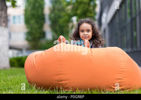 Girl lying on a bean bag and using a digital tablet Stock Photo - Alamy