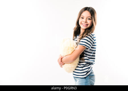 Smiling child standing with heart shaped pillow isolated on white Stock Photo