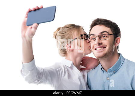 businesspeople in formal wear kissing and taking selfie on smartphone, isolated on white Stock Photo