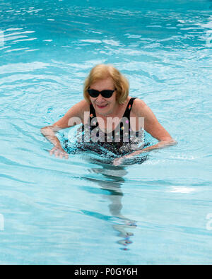 Senior female woman exercising in an outdoor swimming pool; south central Florida; USA Stock Photo