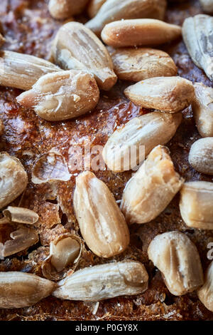 Close up picture of a whole wheat bread crust with sunflower seeds, selective focus. Stock Photo