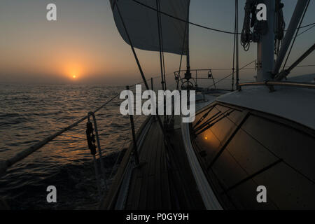 A yacht sailing offshore in light fog at dawn, north of the southern limit for ice, in the North Atlantic north east of Bermuda. Stock Photo
