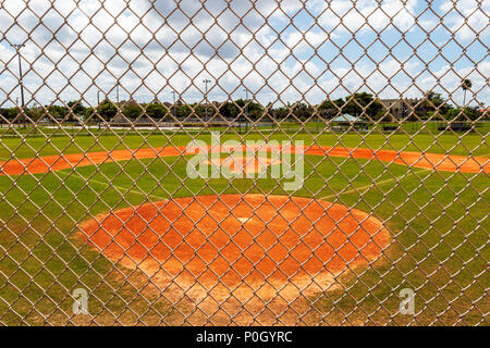 Public park baseball diamond viewed through cyclone fence; south central Florida; USA Stock Photo