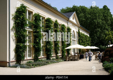 Bad Homburg, Germany - May 19, 2018: Visitors sitting under umbrellas at garden tables at the Orangery in the spa gardens on May 19, 2018 in Bad Hombu Stock Photo