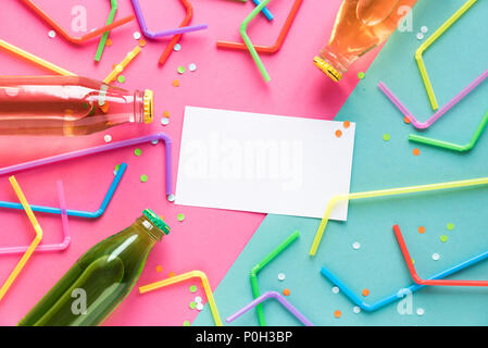 Various cold drinks with straws and confetti on pink and blue background and copy space for text. Summer party, happy vacation and fun concept, top vi