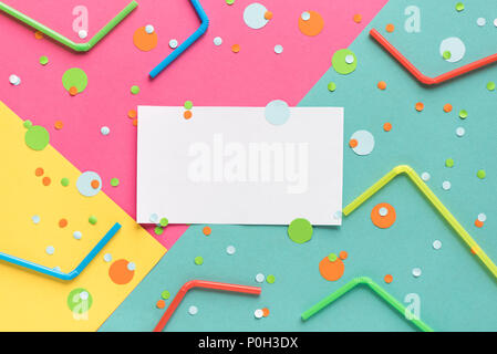 Vibrant confetti and straws on pastel pink, blue, yellow background with white clean blank for your text. Festive backdrop for your design, copy space Stock Photo