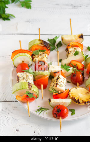 Vegetarian grilling. Vegetarian skewers with halloumi cheese and vegetables on white background, copy space. Stock Photo