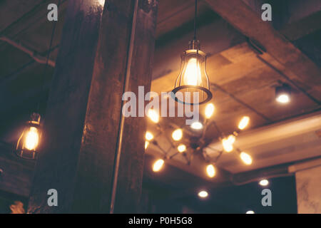 Decorative antique edison style light bulbs against cafe wall background Stock Photo