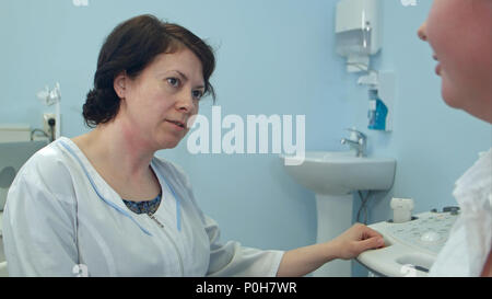 Experienced female doctor talking to patient in the hospital Stock Photo
