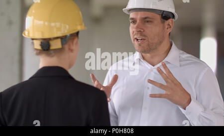Two colleagues in the work plan discussing at a construction site Stock Photo