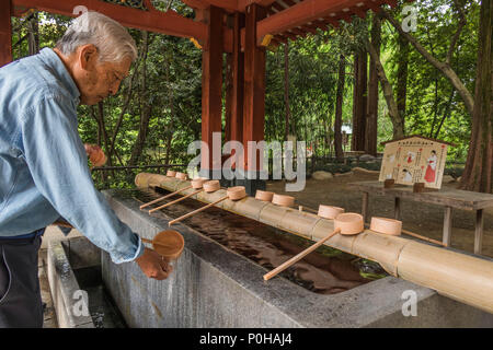 https://l450v.alamy.com/450v/p0haj4/before-entering-a-shinto-shrine-visitors-purify-themselves-with-water-at-the-temizuya-a-man-washes-his-hands-with-bamboo-dipper-hikawa-jinja-shrine-p0haj4.jpg