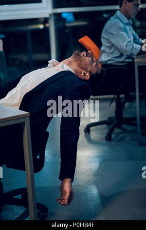 Businessman falling asleep during work. Stock Photo